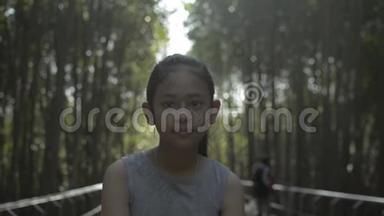 亚洲可爱的女孩在阳光下漫步在红树林的小径上。